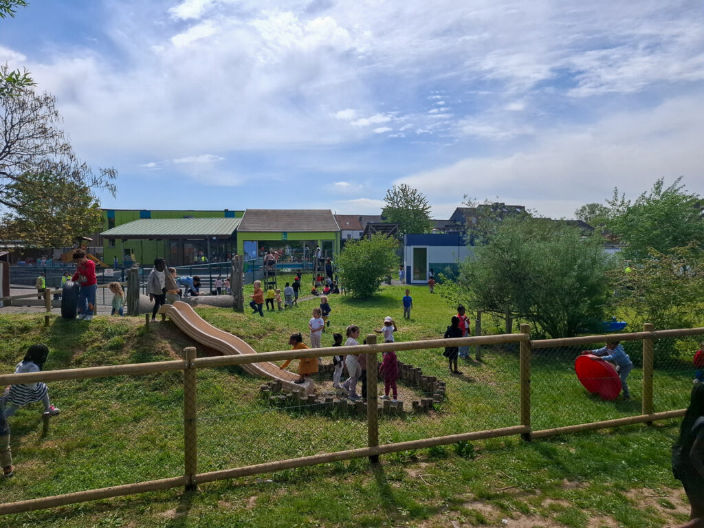 Groene speelplaats met glijbaan en spelende kinderen